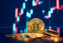 Close-up of Bitcoin coins in front of a trading chart