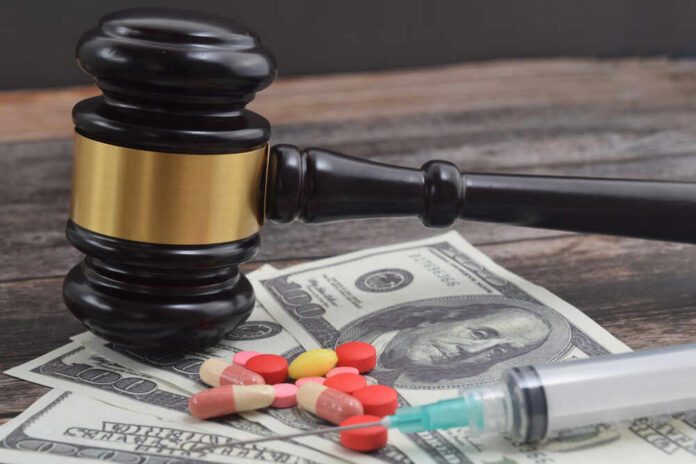 shutterstock_2018299673.jpg A gavel placed on top of money with pills and a syringe nearby