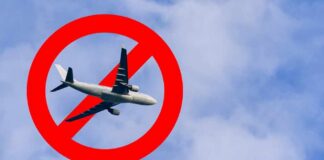 An airplane flying through a cloudy sky with a red prohibition symbol overlay