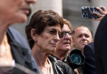 A group of people at an outdoor event with one woman in focus showing a serious expression