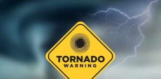 A yellow tornado warning sign against a stormy background