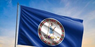 Virginia state flag waving against a sunset sky