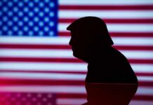 Silhouette of a person against an American flag background