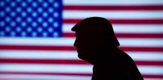 Silhouette of a person against an American flag background