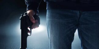 A person holding a handgun in a dark environment