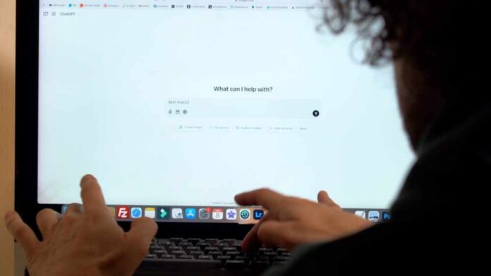 Person interacting with a computer screen displaying a chatbot interface