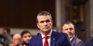 Individual in formal attire seated at a senate hearing