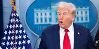 A man speaking at a podium during a press conference at the White House