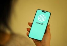 Shocking AI Breach Exposes Millions—Are You At Risk? A person holding a smartphone displaying the ChatGPT logo on a teal background
