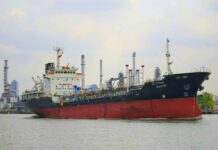 A cargo ship navigating through an industrial harbor