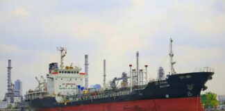 A cargo ship navigating through an industrial harbor