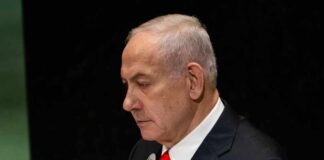 A political leader speaking at the UN assembly with a serious expression