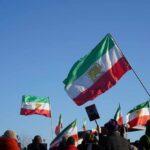 Crowd holding Iranian flags during a protest against the government