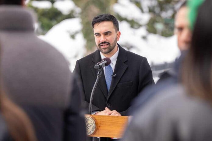 Man in formal attire speaking at a podium during a winter event