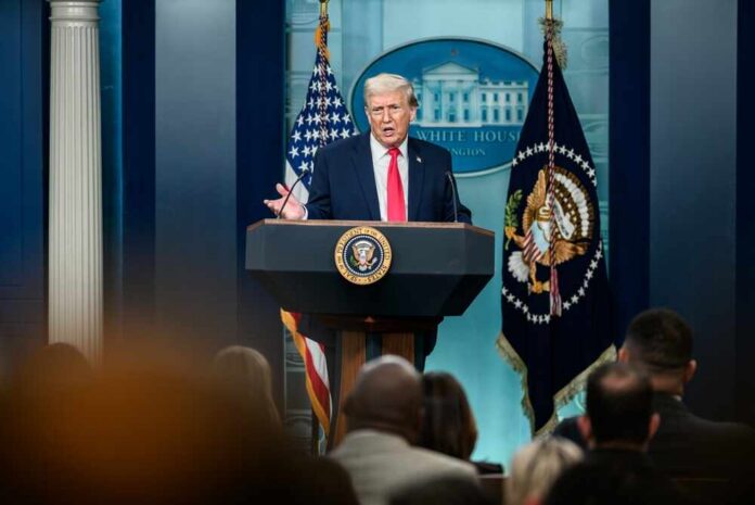 A man speaking at a podium during a press conference at the White House