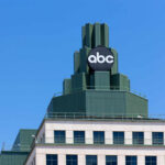 Top of a building featuring a prominent ABC logo against a clear blue sky