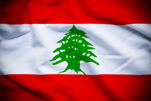 Flag of Lebanon featuring a green cedar tree on a white stripe between red stripes