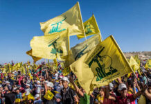 Large crowd waving yellow flags at a political rally