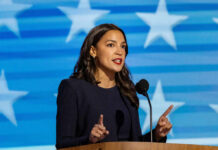 A female politician delivering a speech at a podium with a star-patterned background
