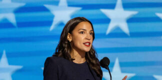 A female politician delivering a speech at a podium with a star-patterned background