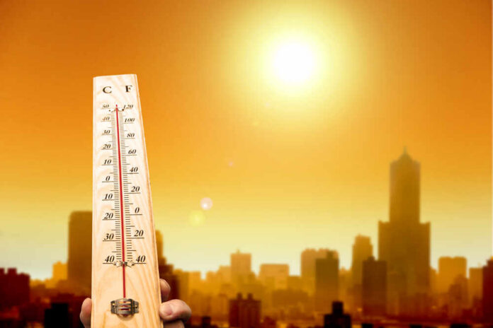 Heat,Wave,In,The,City,And,Hand,Showing,Thermometer,For A thermometer held against a sunset city skyline