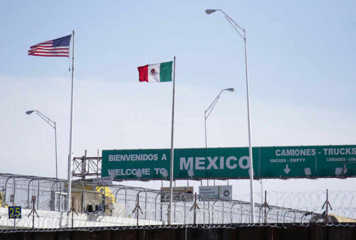 shutterstock_2236173447 Flags of the United States and Mexico at a border crossing with a welcome sign