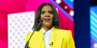 A woman in a bright yellow suit speaking at a podium during a conference