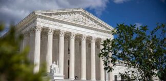 The Supreme Court building with columns and a statue in front