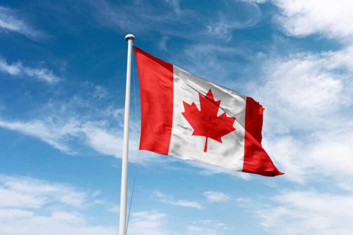 Canada,Flag,Waving,At,Cloudy,Sky,Background. Canadian flag waving against a blue sky