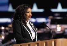 GOP Under Fire: Alleged Evasion on Extremist Threats A woman in formal attire speaking at a podium with a microphone