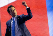 A speaker passionately delivering a speech with a raised fist