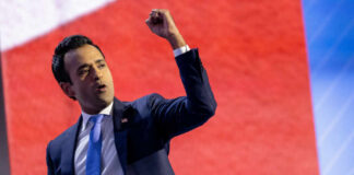 A speaker passionately delivering a speech with a raised fist