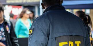 FBI agent in a jacket with 'FBI' on the back at a public event