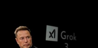 Elon Musk speaking during a technology event with a dark background