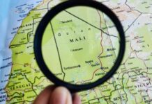 A magnifying glass focusing on a map section of Mali