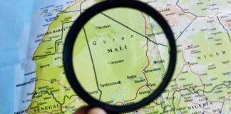 A magnifying glass focusing on a map section of Mali
