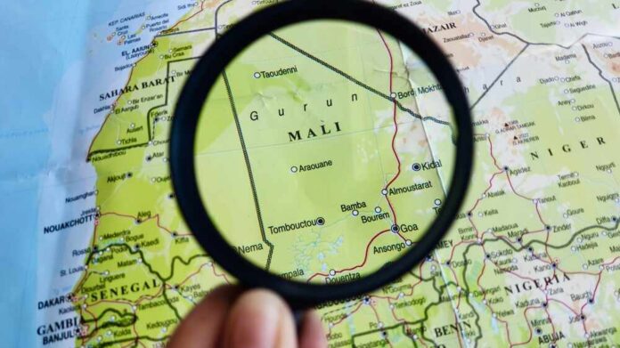 A magnifying glass focusing on a map section of Mali