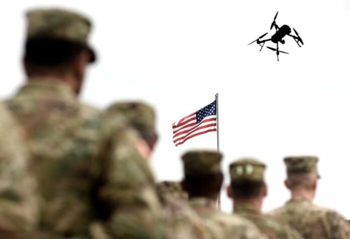 shutterstock_2690863839 Military personnel standing in formation with a drone flying overhead and an American flag in the background