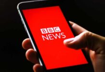 Controversy Erupts: BBC’s Take on Afghan Slavery Hand holding smartphone with a red news app screen