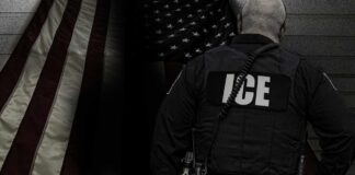 ICE agent standing in front of an American flag