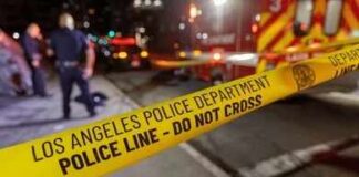 Police tape cordons off a nighttime street scene
