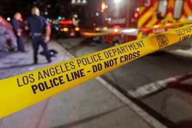 Police tape cordons off a nighttime street scene
