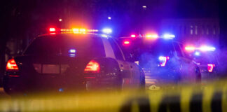 Highway Heroes Beat Flames To Survivors Police cars with flashing lights at a nighttime scene behind crime scene tape