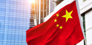 Chinese flag waving in front of modern buildings