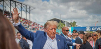 A public figure waving to a crowd at an outdoor event