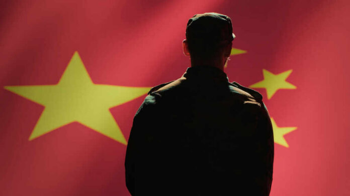 Silhouette of a soldier in front of the Chinese flag