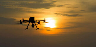 Drone Warfare Enters Dangerous Phase A silhouette of a drone flying against a sunset sky