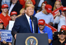 Trump’s Political Machine Crushes Rivals Again A speaker at a political rally smiling in front of an enthusiastic crowd wearing red hats