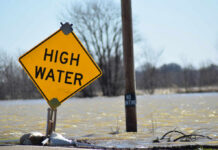 Flood Watches EXPLODE Across Gulf A high water warning sign near a flooded area