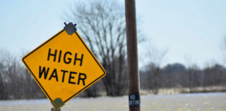 Flood Watches EXPLODE Across Gulf A high water warning sign near a flooded area